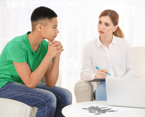 Child mental health counselor talking with an adolescent.