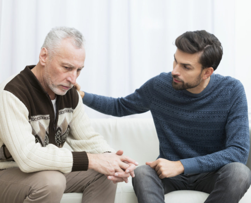 A loved one provides comfort to a grieving person going through the stages of loss.