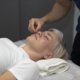 A woman receiving facial acupuncture treatment to reduce sinus pressure.